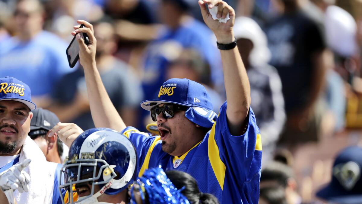 Rams fans cheer as the team takes the Coliseum field for its scrimmage on Aug. 6.