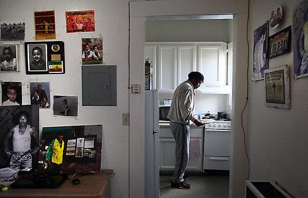 Seifu Mekonnen, a two-time Olympic boxer from Ethiopia, prepares lunch in his apartment in Los Angeles. He is undergoing treatment for kidney disease and is waiting for a transplant.