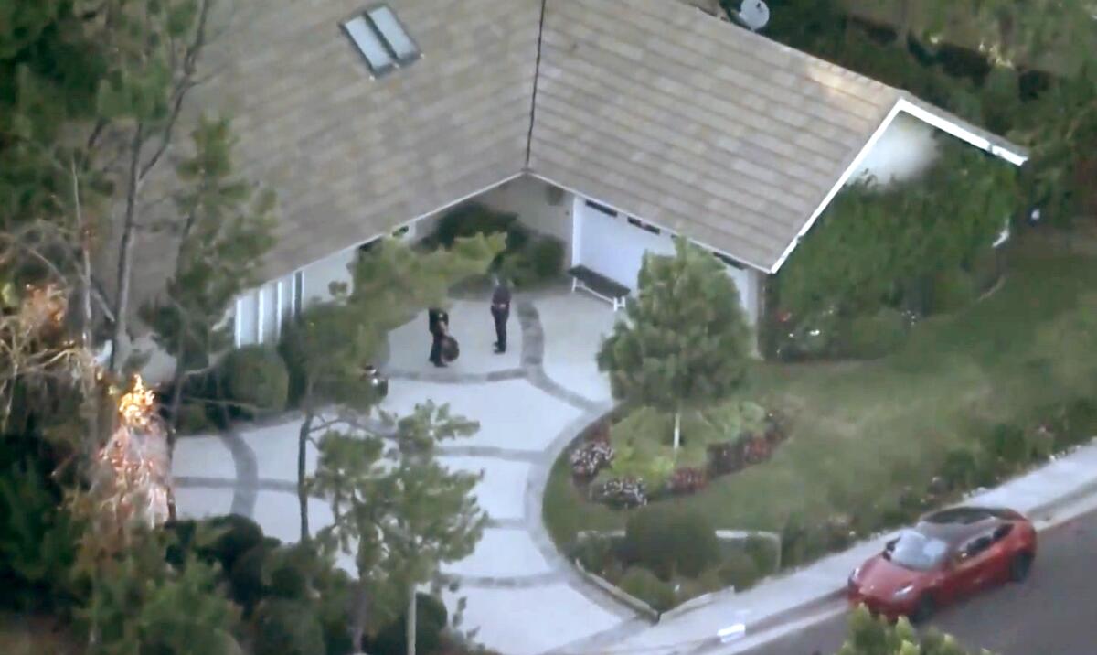 An aerial view of police outside a home.
