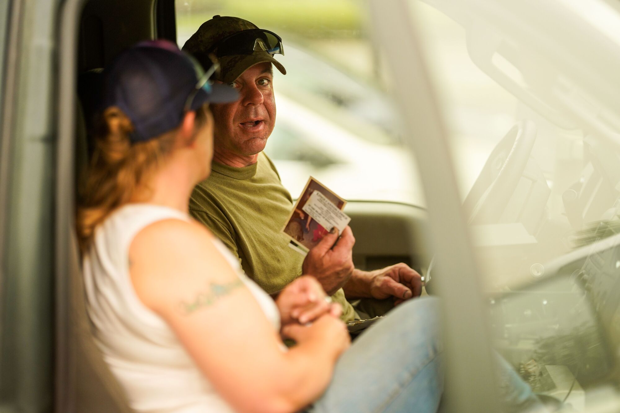 Niles and Gabrielle Kant look at photographs in the cab of their truck.