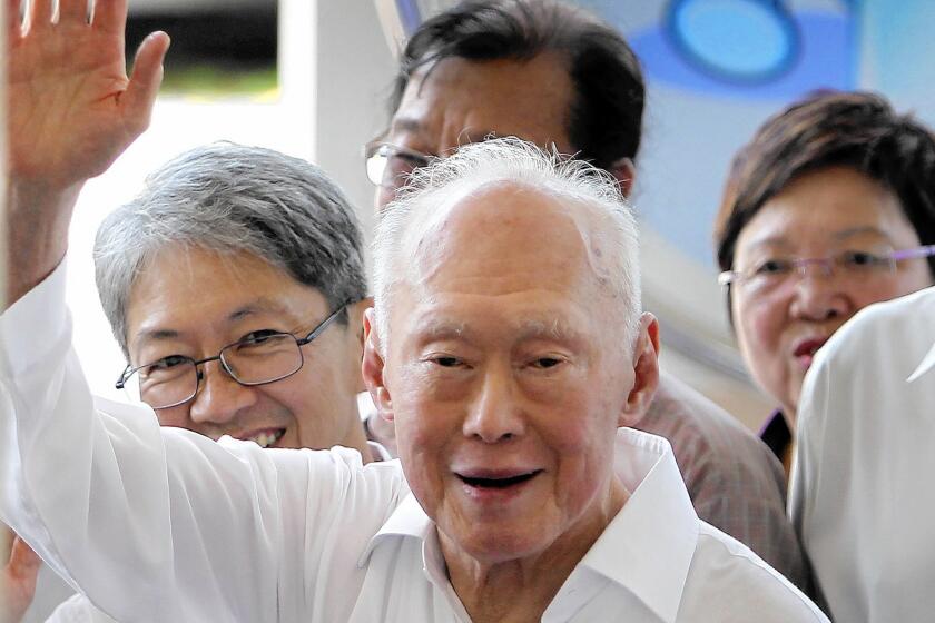 Singapore's former prime minister, Lee Kuan Yew, waves to supporters as he arrives at an elections nomination center in Singapore.