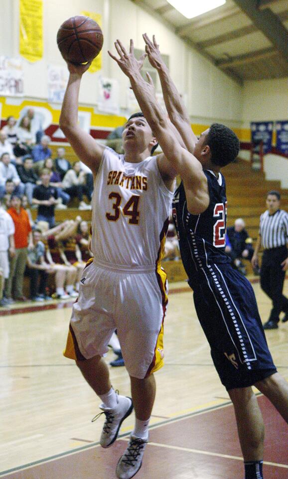 La Canada's Kyle Thomas drives for a layup and is fouled hard by La Salle's Conor Williams in a non-league boys basketball game at La Canada High School on Friday, January 10, 2014. La Canada won the game which marks Coach Tom Hofman's 600th win. (Tim Berger/Staff Photographer)