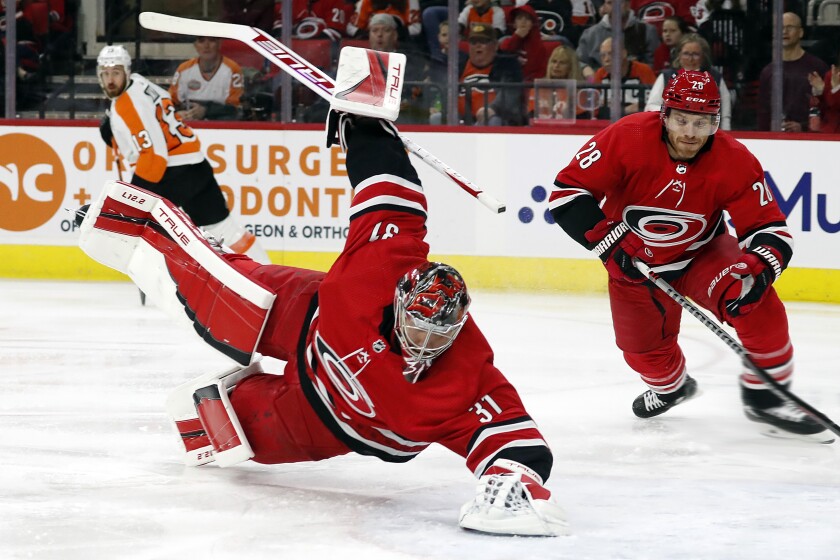 Carolina Hurricanes goaltender Frederik Andersen (31) dives on the puck that was shot by Philadelphia Flyers' Kevin Hayes (13) with Hurricanes' Ian Cole (28) nearby during the first period of an NHL hockey game in Raleigh, N.C., Saturday, March 12, 2022. (AP Photo/Karl B DeBlaker)