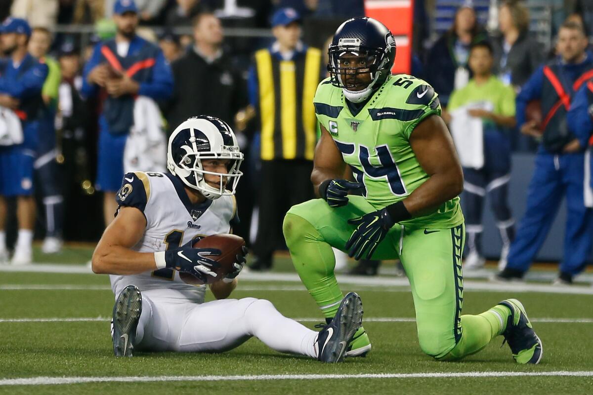 Rams receiver Cooper Kupp and Seahawks linebacker Bobby Wagner look on after Kupp scored a touchdown Oct. 3, 2019. 