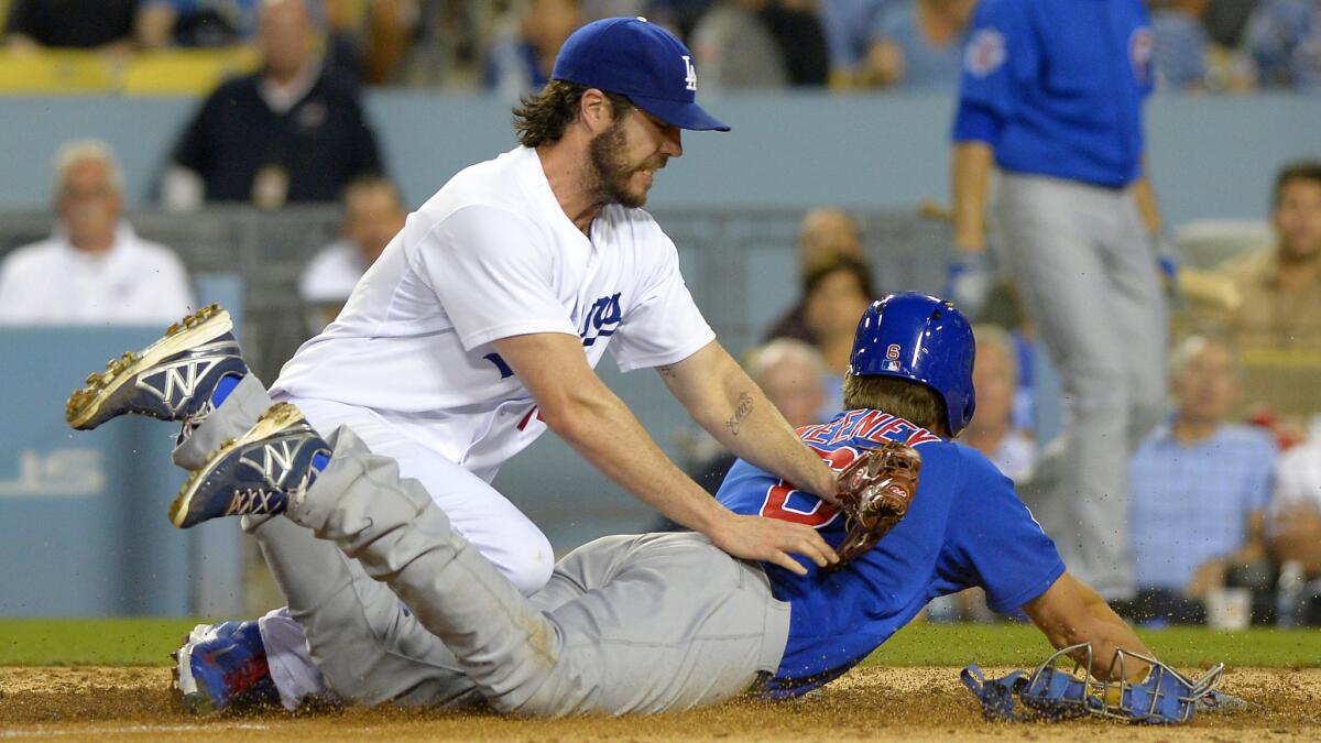 Chicago Cubs baserunner Ryan Sweeney, right, scores on a wild pitch from Dodgers starter Dan Haren, left, who is unable to tag him out at home plate during the third inning of Friday's game.