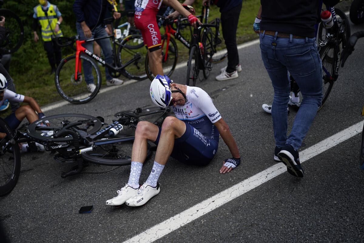 Former Tour de France champion Chris Froome sits on the road after crashing during the first stage of the Tour de France.