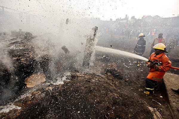 Firefighters try to put out smoldering wood after an explosion in a slum in Nairobi, Kenya. The explosion happened as people gathered to collect leaking gasoline. (Note: Some of the images in this gallery may be disturbing to some readers.)