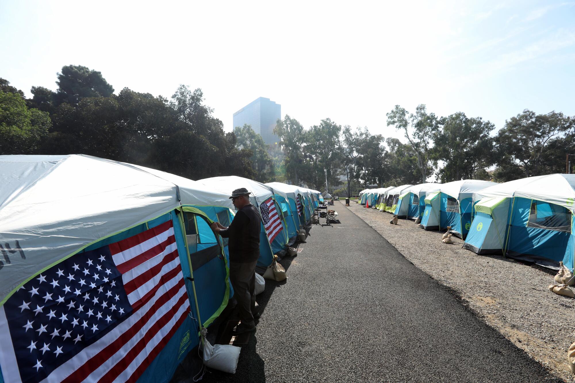  U.S. Army Veteran David Lawrence Echavarria, 60, zips up one of many tents.