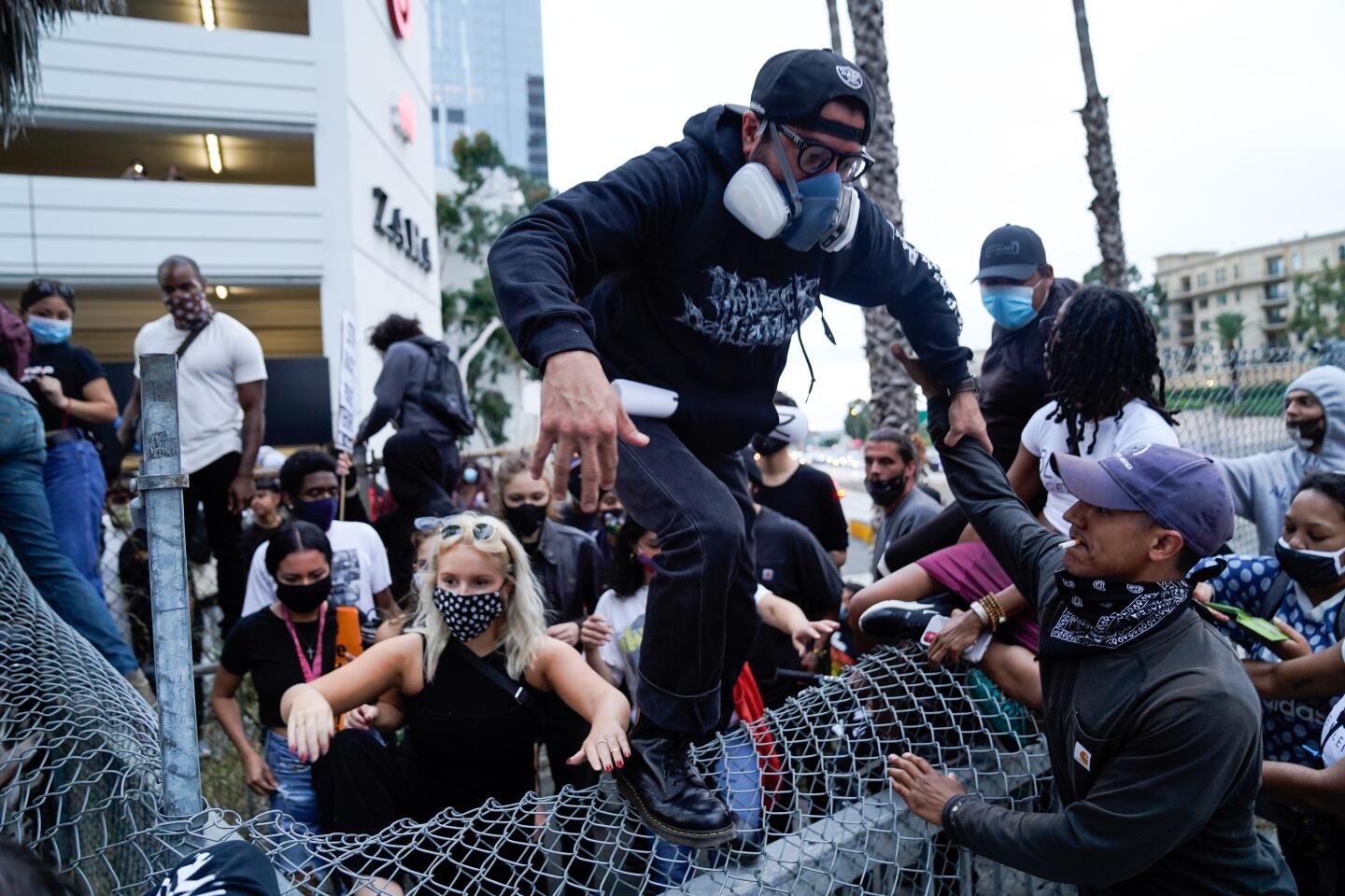 Protesters climb over a barrier during the May 29 protest in downtown L.A.