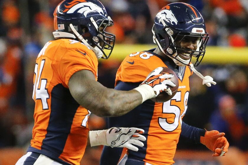 Broncos linebacker DeMarcus Ware, left, celebrates after recoveing a fumble with fellow linebacker Von Miller during a divisional playoff game against the Steelers on Jan. 17.