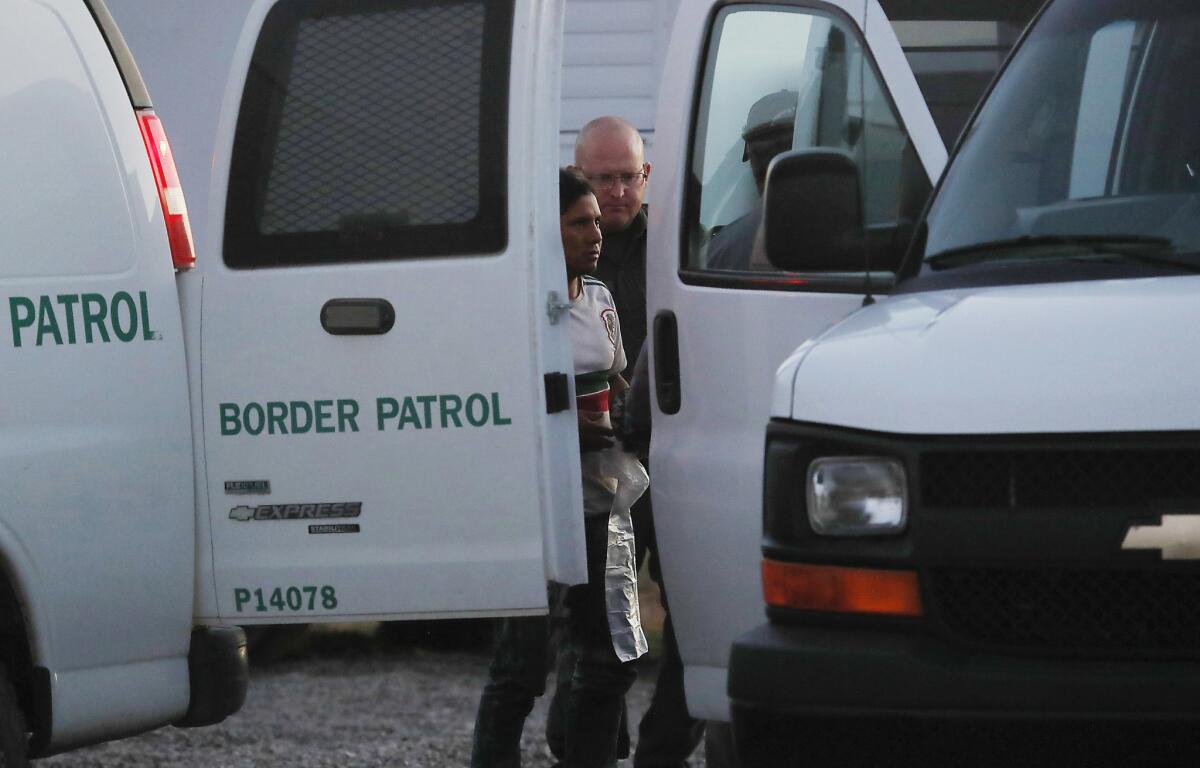 Border Patrol agents transfel migrants apprehended on the Tohono O'odham Nation for transport to a facility in nearby Tucson. (Luis Sinco / Los Angeles Times)