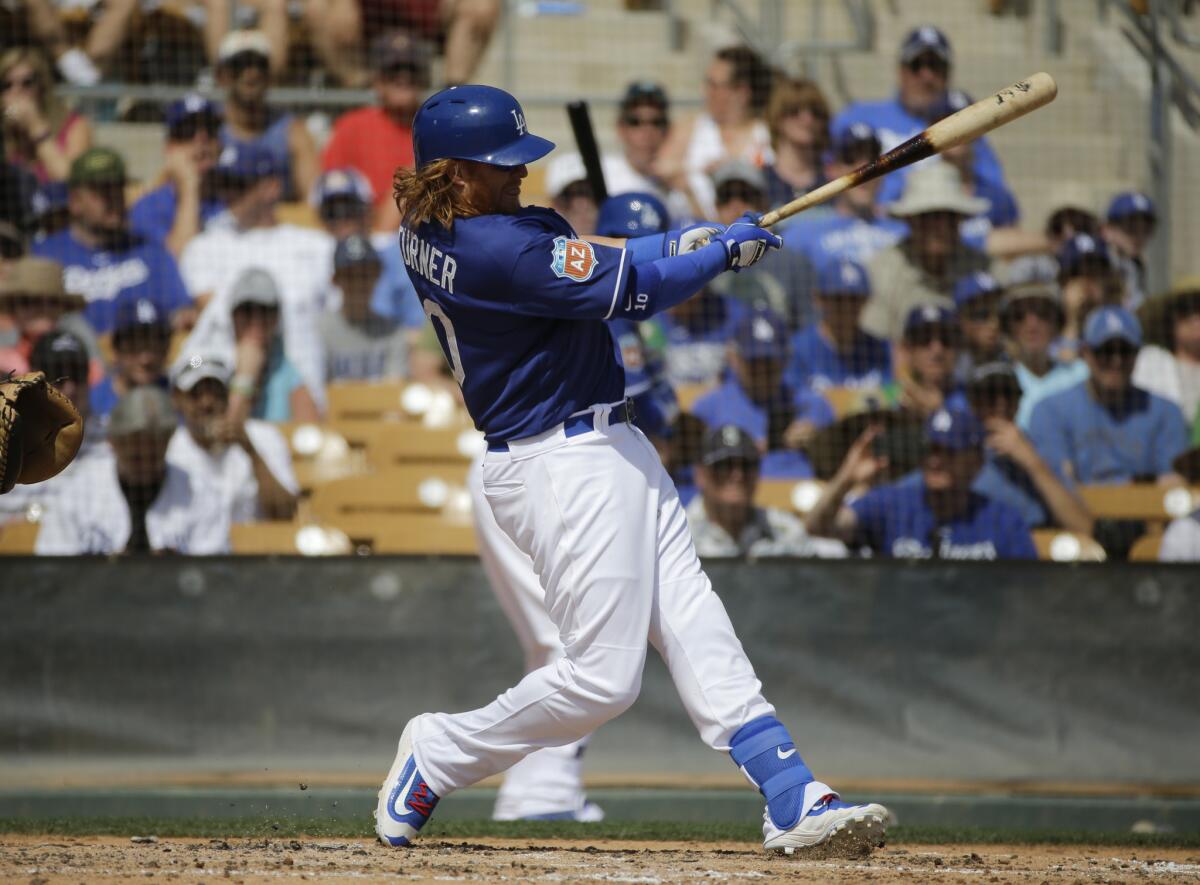 Dodgers third baseman Justin Turner hits during a spring training baseball game against the Mariners on March 21.