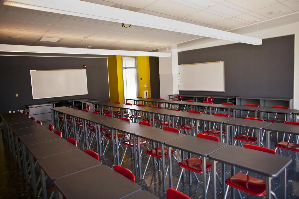 An empty classroom has desks placed close together before the coronavirus pandemic.