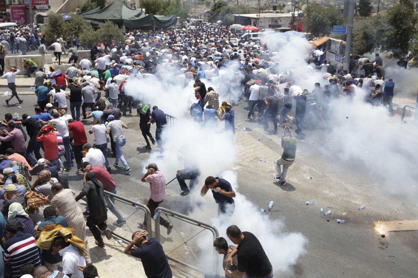 Palestinian protesters are driven back by tear gas fired by Israeli police officers outside Jerusalem's Old City.