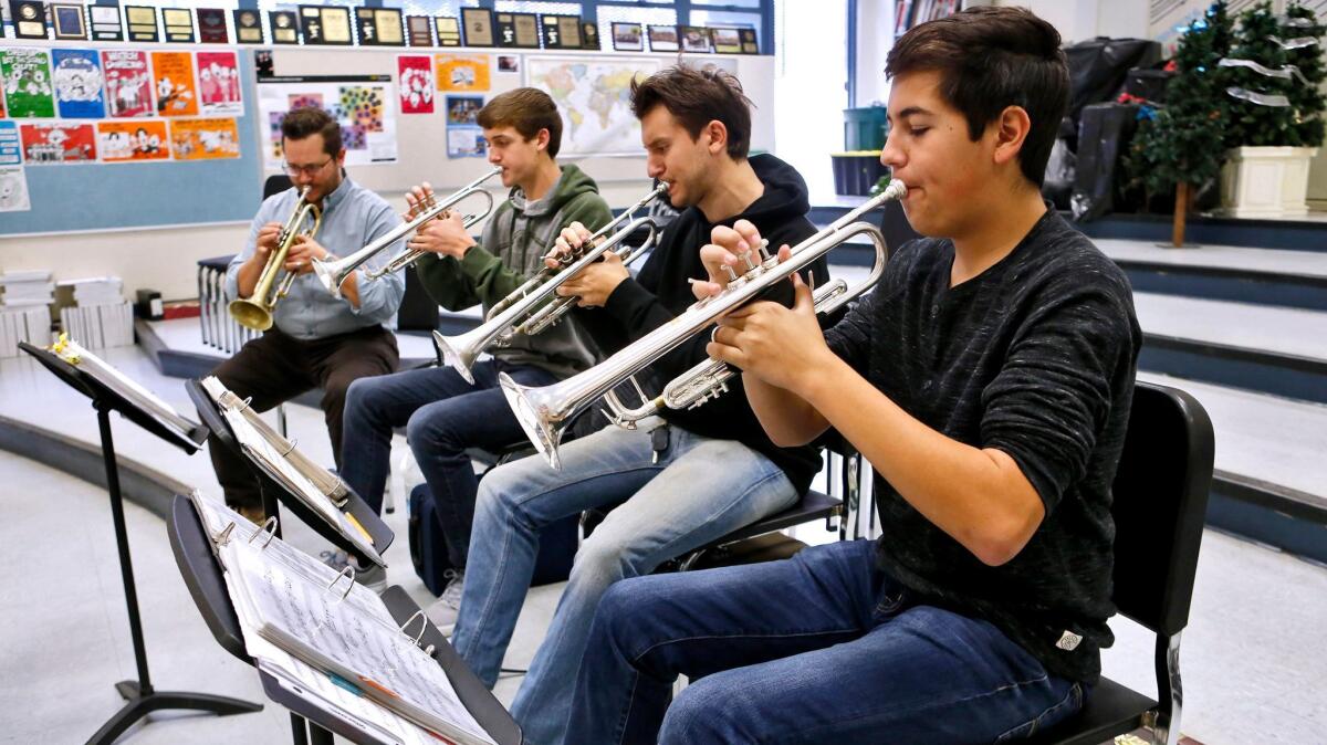 From left, trumpet teacher Mike Davis plays alongside students Carter Walch, Gregory Pappas and Nick Sandoval, during jazz class at Crescenta Valley High School on Thursday. The Glendale Educational Foundation will donate money to the jazz band to purchase Right Books.