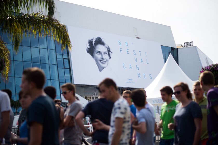 People pass by the official poster of the 68th Cannes Film Festival in southeastern France.