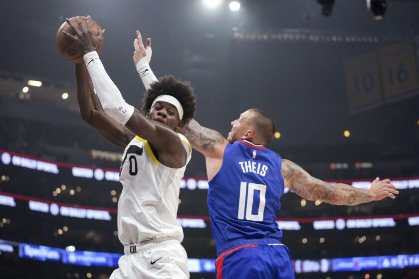 Utah Jazz forward Taylor Hendricks (0) and Los Angeles Clippers center Daniel Theis (10) reach for a rebound during the first half of an NBA basketball game in Los Angeles, Friday, April 12, 2024. (AP Photo/Eric Thayer)