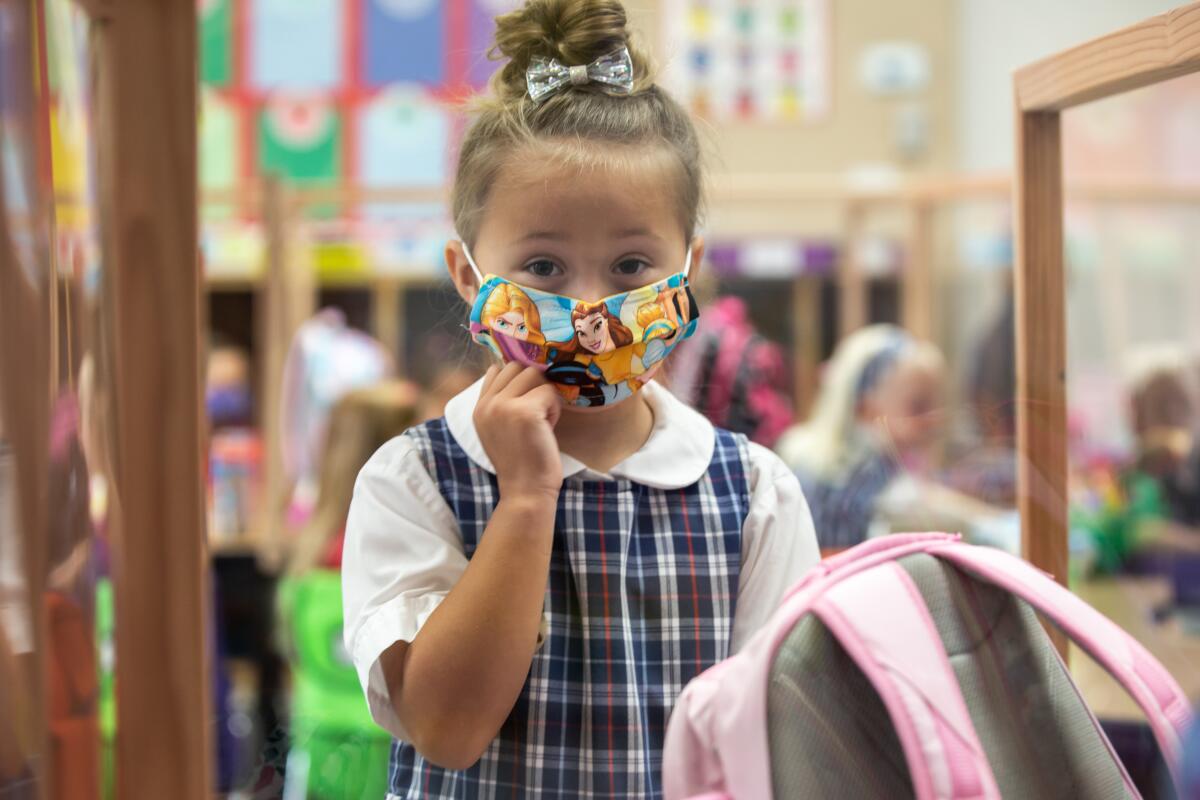 A second grader adjusts her face mask at Christian Unified on Monday, Aug. 24, 2020 in El Cajon.