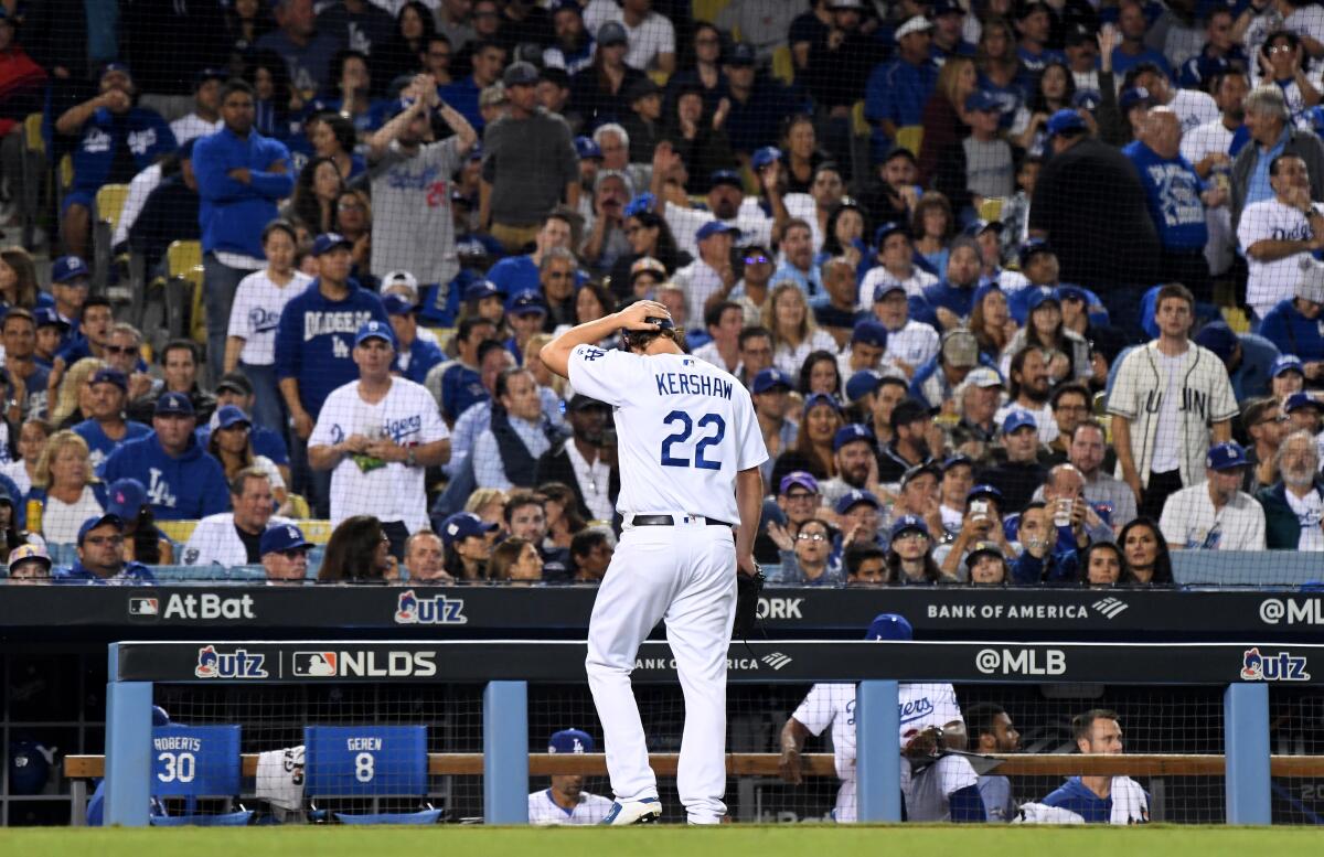 Dodgers pitcher Clayton Kershaw walks back to the dugout after giving up two solo home runs to the Washington Nationals in the eighth inning in Game 5 of the NLDS at Dodger Stadium on Wednesday.