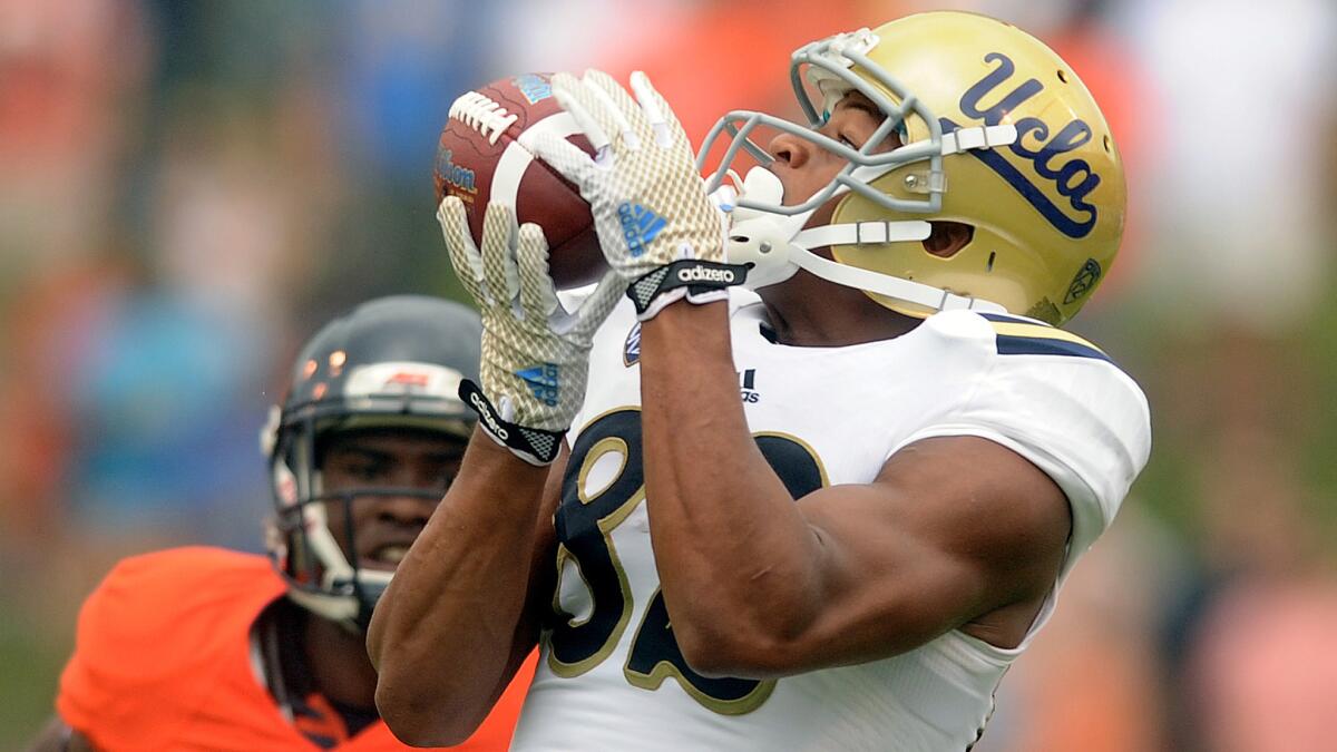 UCLA wide receiver Eldridge Massington hauls in a long pass during the Bruins' win over Virginia on Aug. 30.