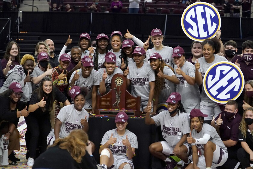 Members of the Texas A&M basketball team pose for pictures after winning the SEC regular-season championship after a win over South Carolina an NCAA college basketball game Sunday, Feb. 28, 2021, in College Station, Texas. (AP Photo/Sam Craft)
