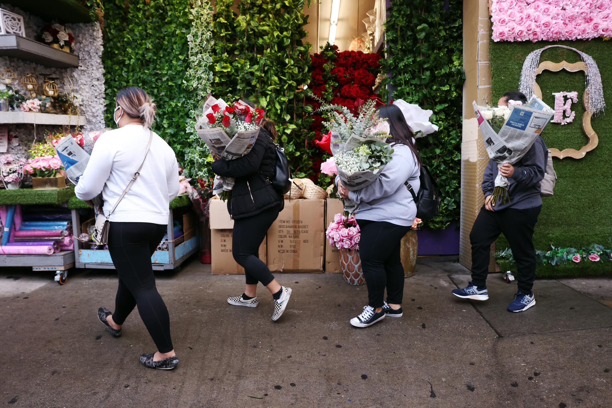 People exit the Los Angeles Flower Market with their purchases.
