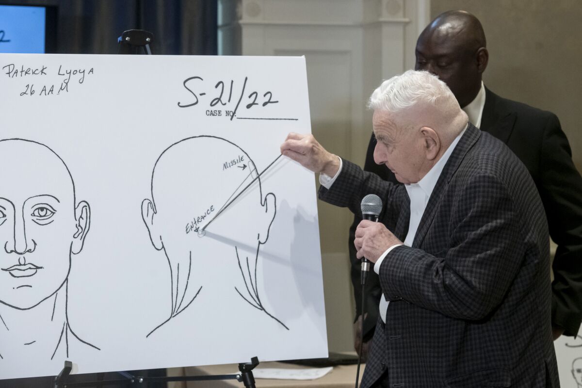 Forensic pathologist Dr. Werner Spitz uses a chart to demonstrate the direction of the bullet that killed Patrick Lyoya during a press conference at the Westin hotel in Detroit, Tuesday, April 19, 2022. Lyoya died of a gunshot wound to the back of head after a confrontation with a Grand Rapids, Mich., police officer during an April 4 traffic stop according to Dr. Spitz. (David Guralnick/Detroit News via AP)