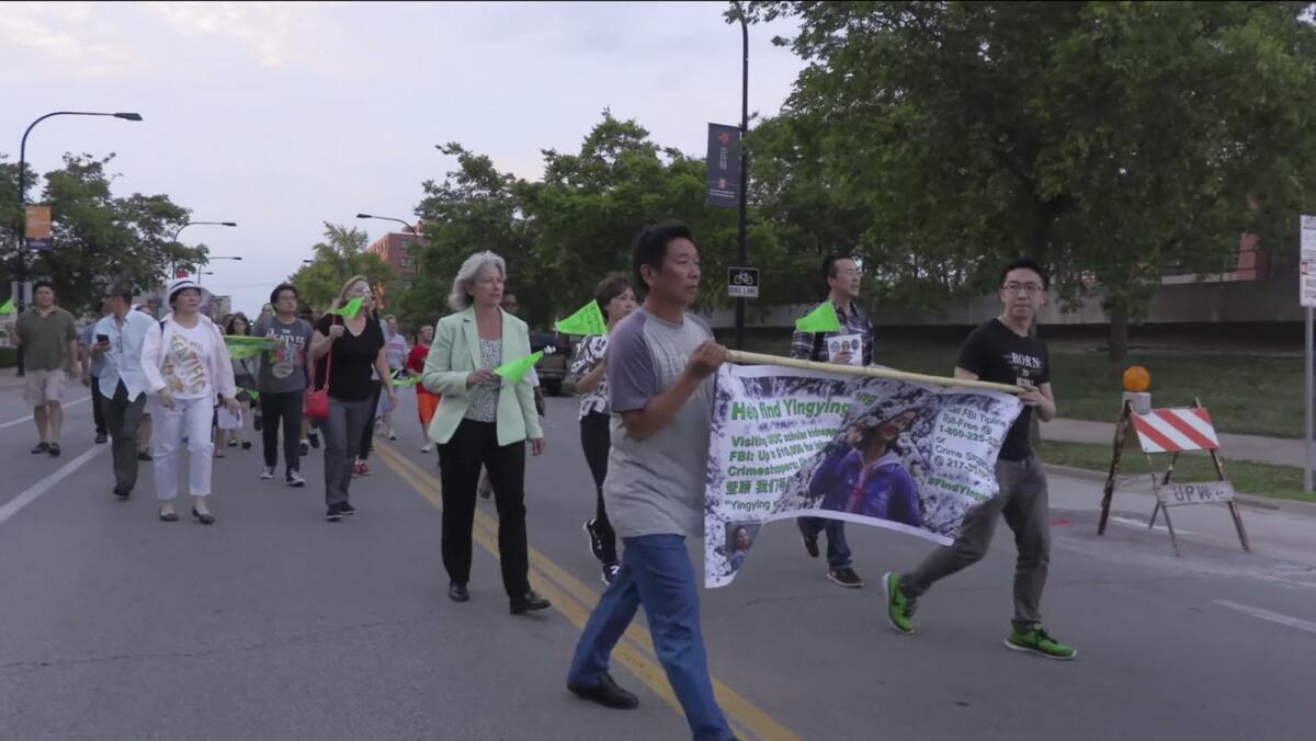 Ronggao Zhang and Xiaolin Hou lead a march in the documentary "Finding Yingying."