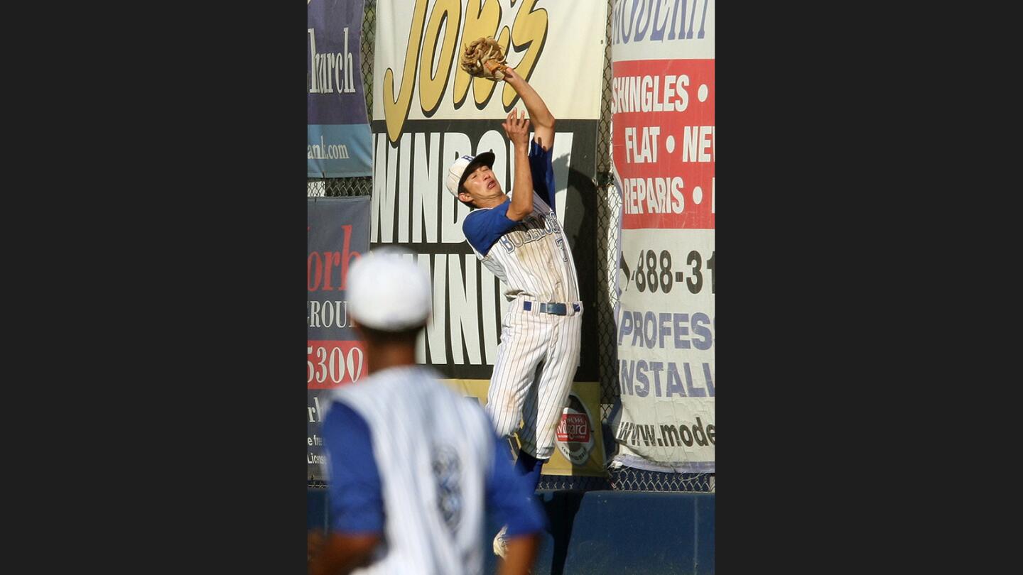 Burbank's Branden Phillips jumps at the back fence to make a hit on a deep fly ball hit by Capistrano Valley Christian in second round of CIF playoffs at Burbank High School on Tuesday, May 23, 2017. Burbank nearly came back to win the game in the seventh inning, but fell short and lost 6-5.