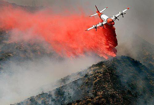 An aerial tanker drops a load of retardant on the northern flank of a fire near Castaic.