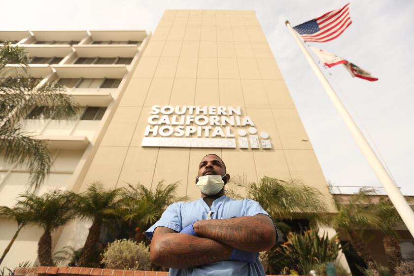 HOLLYWOOD, CA - MARCH 31, 2020 - Andre Ross, 30, is a floor care specialist at Southern California Hospital in Hollywood on March 31, 2020. He disinfects the floors of patients rooms at the hospital and possibly rooms with COVID-19 patients. "If you don't have any direct patient contact you only get a mask," Ross said. When working with possible COVID-19 patients he wears the proper protective gear - a mask, face shield, gloves, gown and booties. "We're doing the best we can," Ross said about the busy days at the hospital. "Everyday is like a battlefield here. You don't know what to expect or what's going to happen," Ross concluded. At hospitals, non-clinical staffers like janitors, cafeteria workers and records clerks are at risk because of COVID-19. But many feel even less protected than doctors and nurses amid personal protective gear shortages. (Genaro Molina / Los Angeles Times)