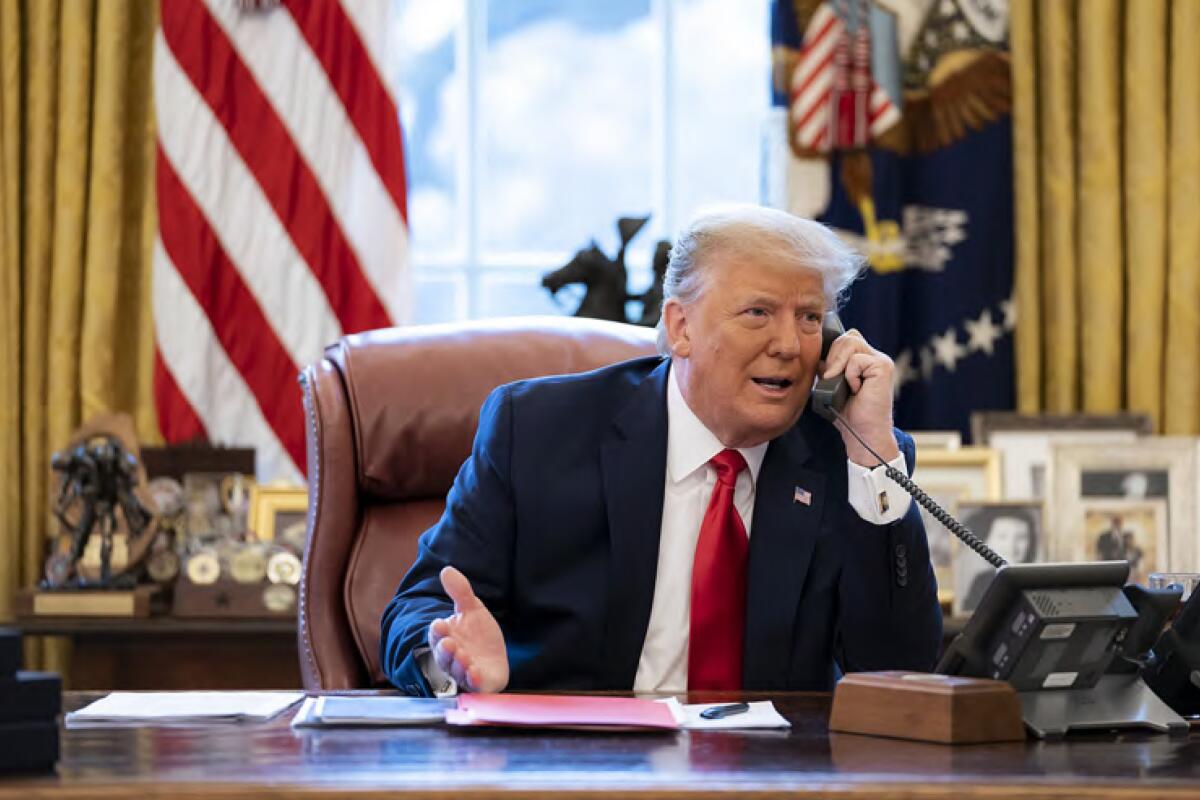 Former President Trump using a telephone in the Oval Office