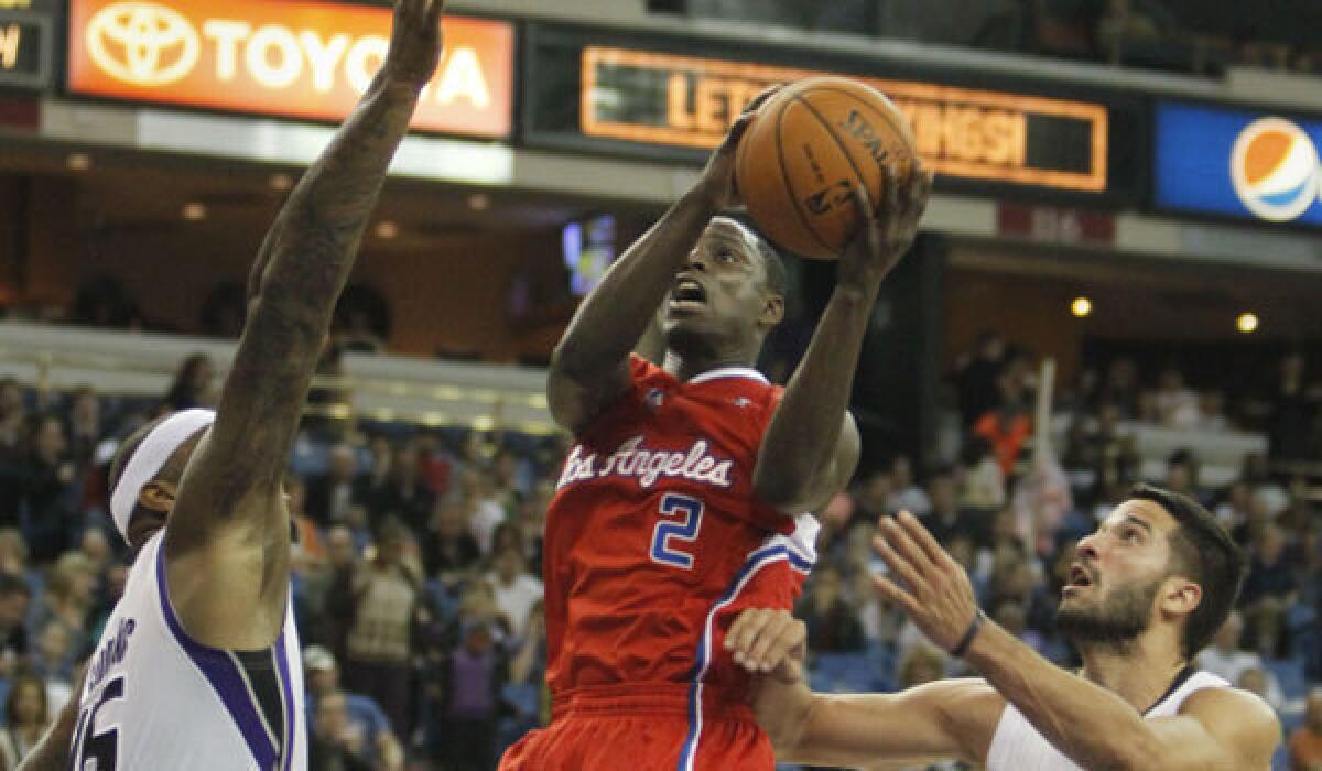 Clippers guard Darren Collison drives to the basket between Sacramento's DeMarcus Cousins, left, and Greivis Vasquez on Monday night.