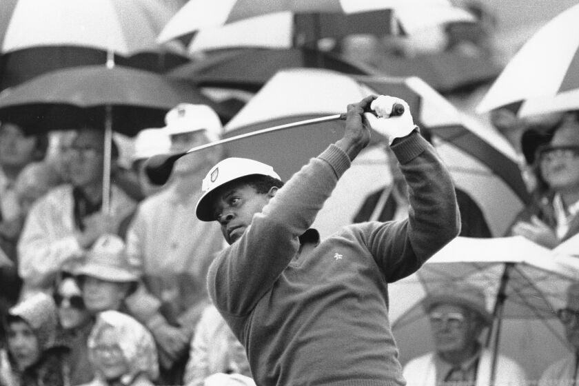 Lee Elder watches the flight of his ball as he tees off in the first round of play at the Masters in Augusta, Ga., on April 10, 1975. (AP Photo)
