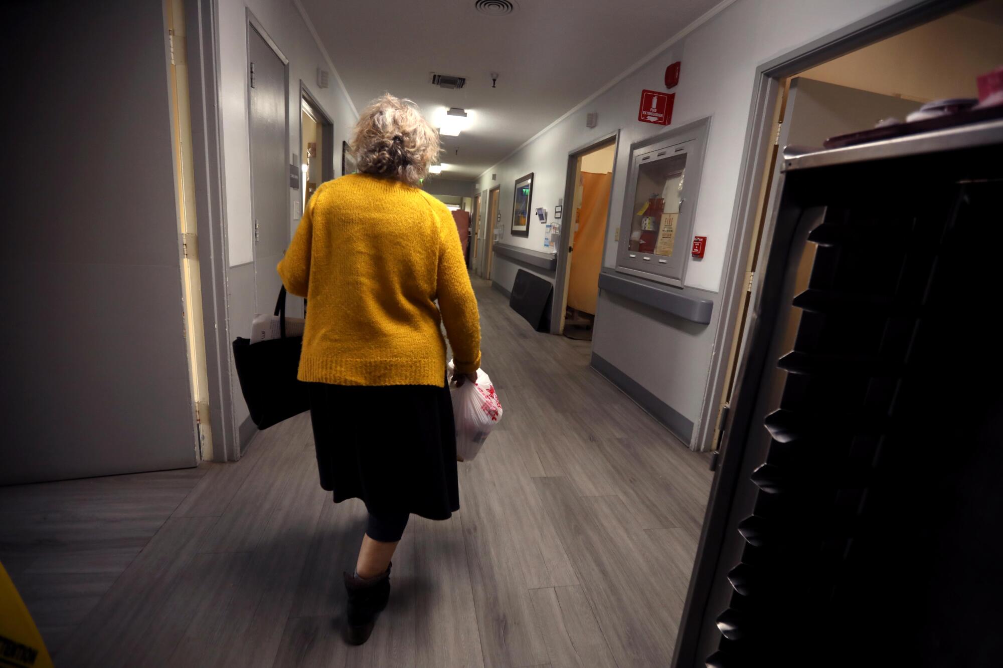 Channah Obadia walks through a nursing care facility where she brings dinner for her sister.