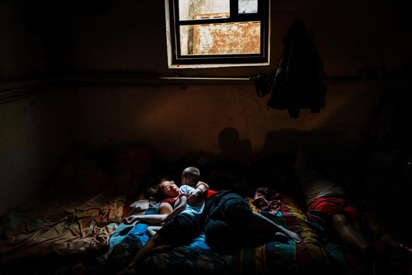 VELYKA NOVOSILKA, UKRAINE -- JUNE 4, 2022: Natalia Tishenko, 46, comforts her son, Yaroslav, 7, as the family has spent more than 2 months underground in a bomb shelter near Velyka Novosilka, Ukraine, Saturday, June 4, 2022. Their home was damaged by bombardment. They are waiting to return to repair it. OItOs really hard mentally. We have no place to go, and we are better off staying here and hoping for the best.O Evacuation is not an option for their family because of costs. OItOs expensive to live in Lviv. WhoOs going to pay for our evacuation?O (MARCUS YAM / LOS ANGELES TIMES)