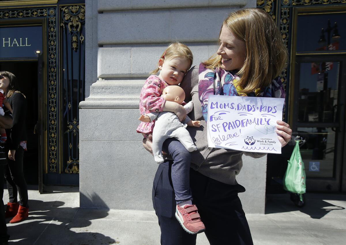 Kim Turner holds her daughter, Adelaide, before a rally in support of paid family leave at San Francisco City Hall on Tuesday.