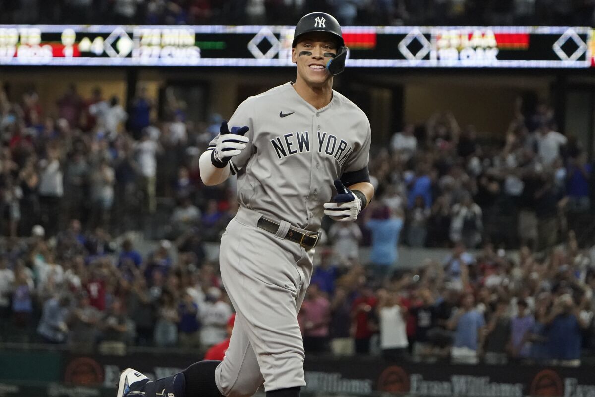 FILE - New York Yankees' Aaron Judge gestures as he runs the bases after hitting a solo home run, his 62nd of the season, during the first inning in the second baseball game of a doubleheader against the Texas Rangers in Arlington, Texas, Tuesday, Oct. 4, 2022. With the home run, Judge set the AL record for home runs in a season, passing Roger Maris. Judge won the American League MVP Award on Thursday, Nov. 17, 2022, in voting by a Baseball Writers' Association of America panel. (AP Photo/LM Otero, File)