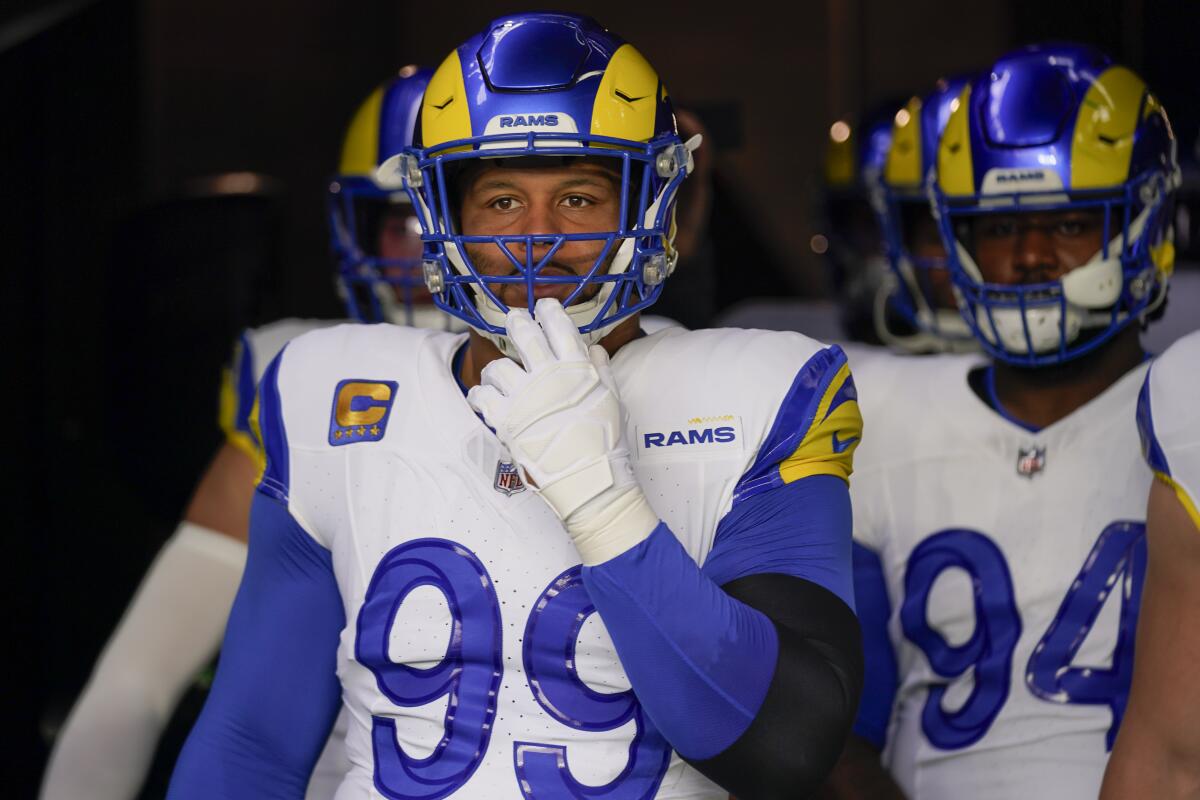Aaron Donald tugs on the facemask of his helmet with his Rams teammates in the tunnel before a game.
