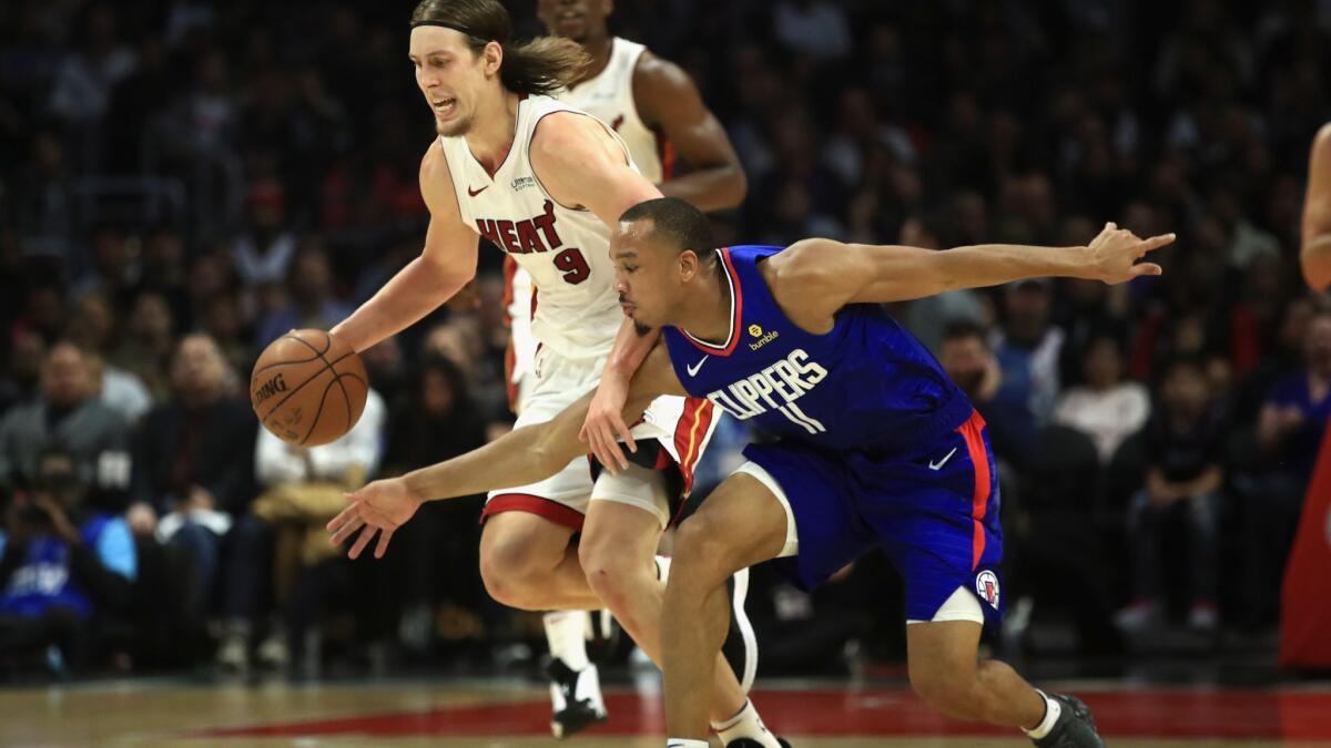 Miami Heat's Kelly Olynyk (9) dribbles past the defense of Clippers' Avery Bradley (11) during the second half of a game at Staples Center on Saturday.