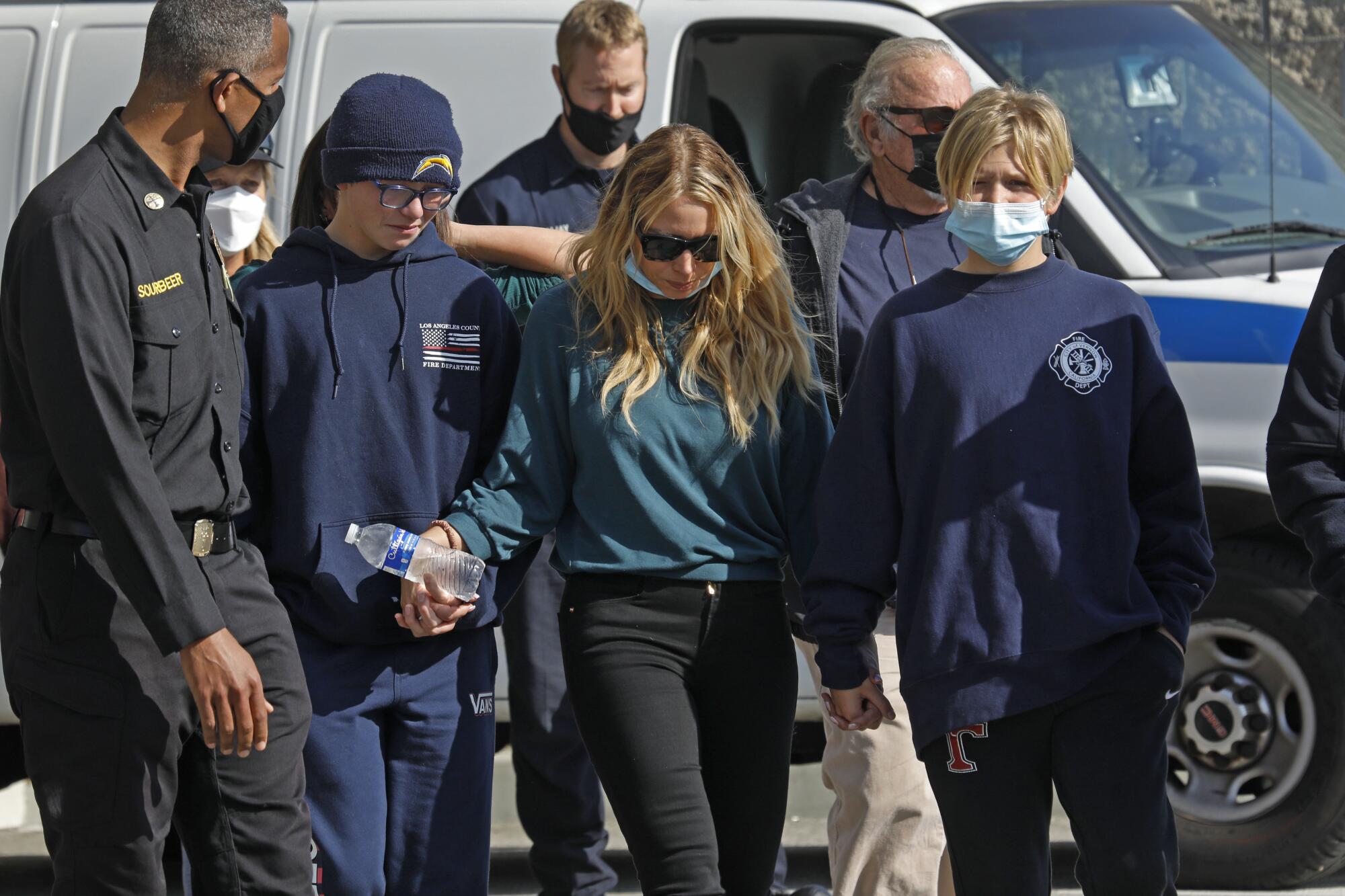 Jonathan Flagler's wife, Jenny, and sons leave are joined by firefighters