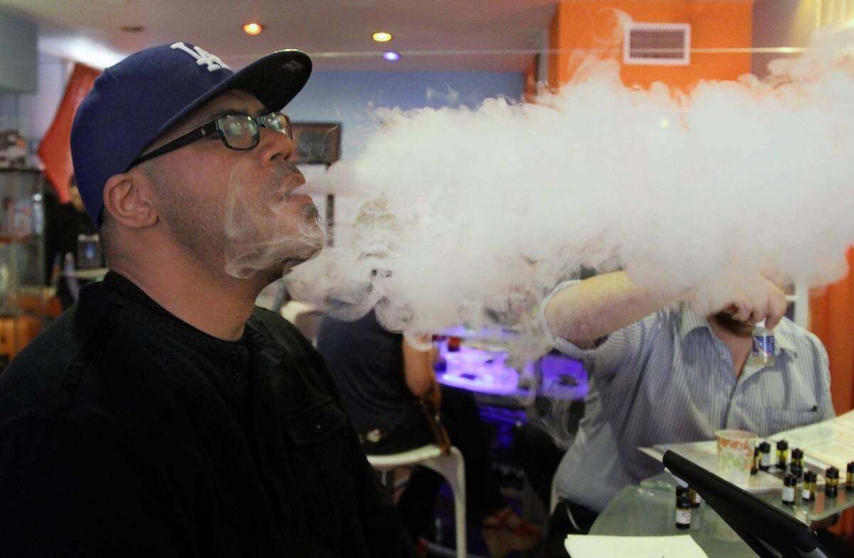 Customer Eric Trotter "vapes" at the Vapor Spot in Westwood.