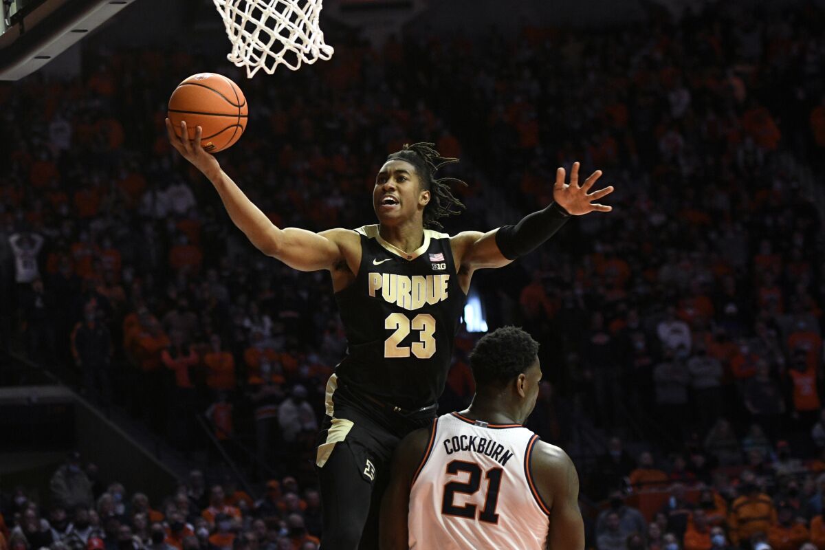 Purdue's Jaden Ivey (23) lays the ball up as he runs into Illinois' Kofi Cockburn during the first overtime of an NCAA college basketball game, Monday, Jan. 17, 2022, in Champaign, Ill. (AP Photo/Michael Allio)