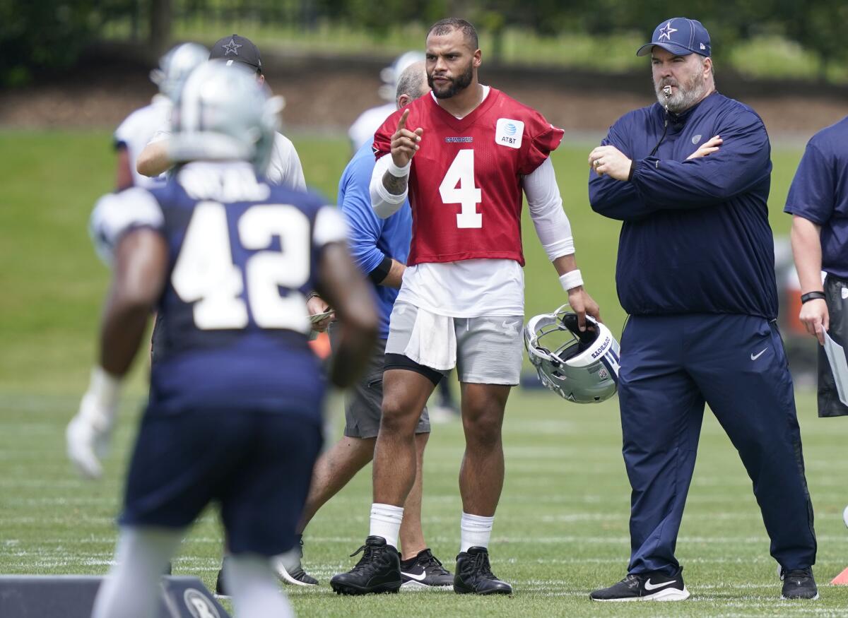 Dallas Cowboys quarterback Dak Prescott stands with coach Mike McCarthy as they watch drills during practice
