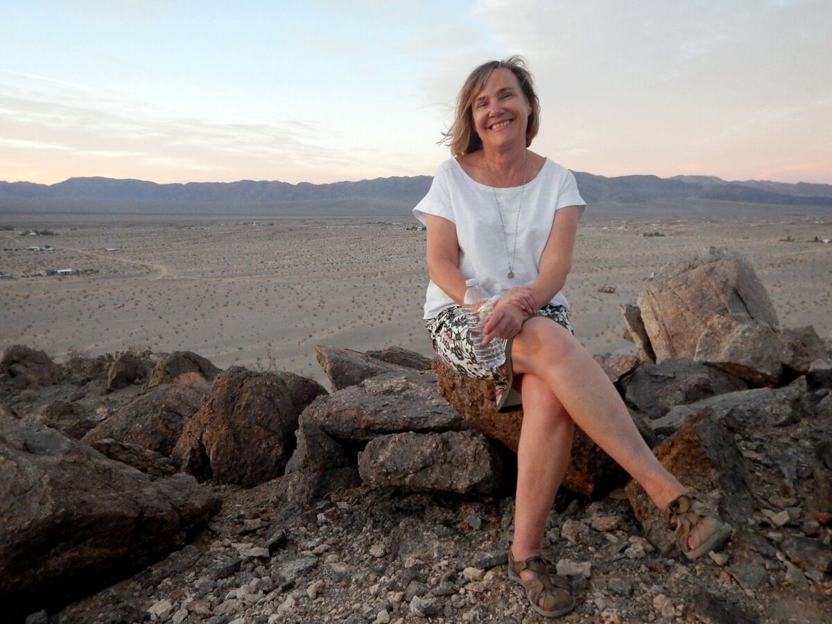 Janet Moore, sitting on large rocks on a trip to Europe and northern Africa in August.