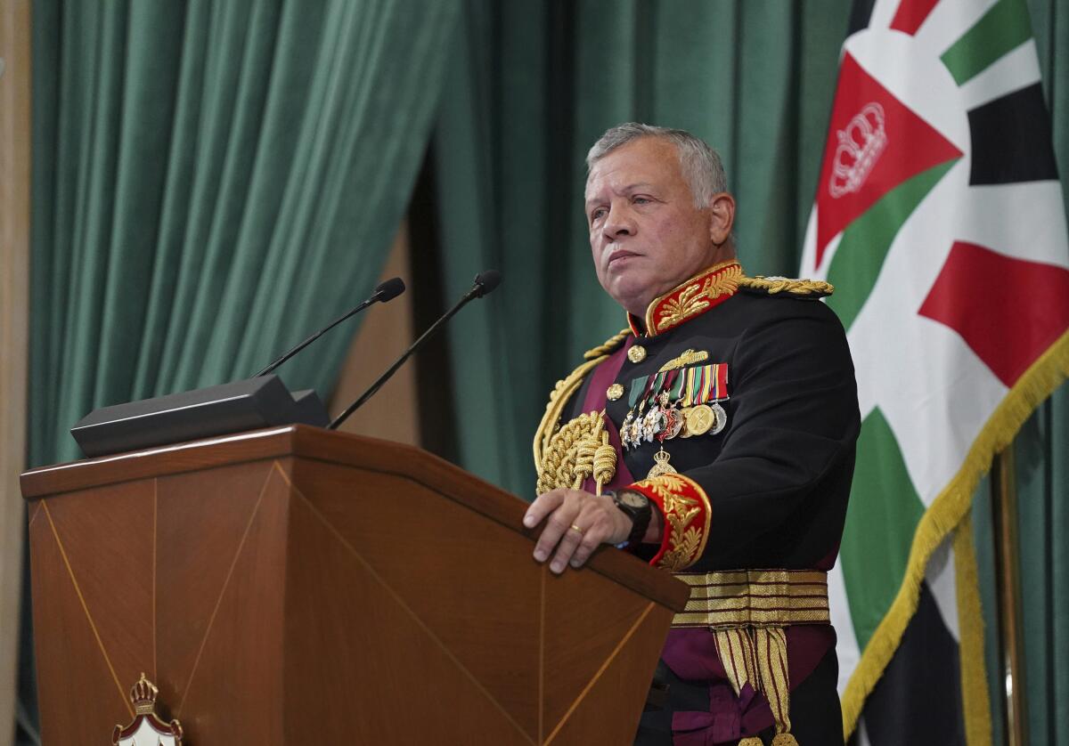 Jordan's King Abdullah II stands at a lectern with a flag behind him