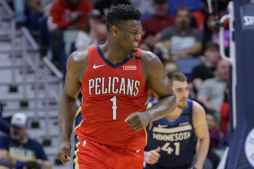 New Orleans Pelicans forward Zion Williamson (1) smiles after dunking on Minnesota Timberwolves forward Juan Hernangomez (41) in the first half of an NBA basketball game in New Orleans, Tuesday, March 3, 2020. (AP Photo/Matthew Hinton)