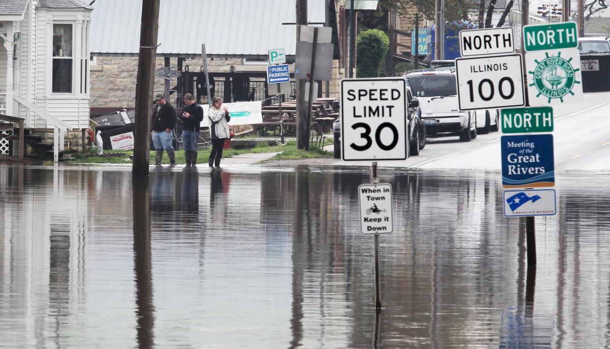 Water covers the intersection of Illinois State Route 100 and Route 3 in Grafton, Ill., on Tuesday. Swollen rivers in the Midwest are expected to remain at high levels into next month.