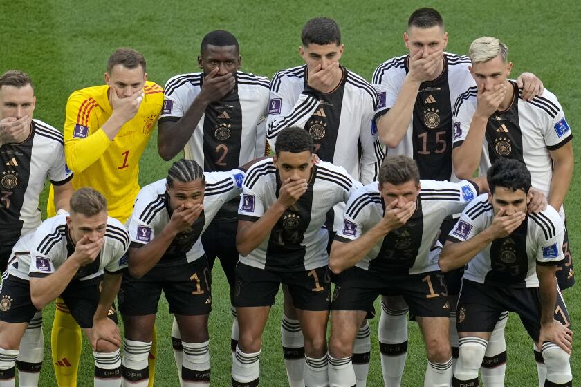 German soccer players cover their mouths as they pose for a group photo before their World Cup match 
