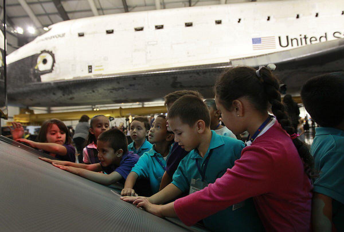 Kindergartners from the Science Center School interact with a video exhibit showing highlights of Endeavour's missions during opening ceremonies at the California Science Center.